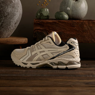 ASICS GEL-KAYANO 14 Imperfection Pack sneakers in cream with crackled leather, exposed foam accents, and aged aesthetic details.