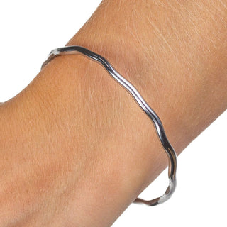 Silver bangle with ripple-inspired wave design in stainless steel