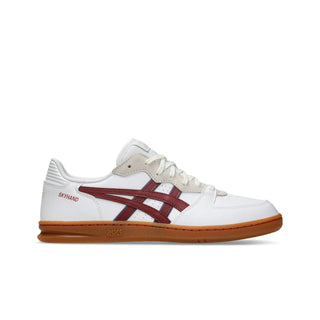 ASICS SKYHAND OG sneaker in white and brisket red with suede paneling, gum outsole, and retro handball-inspired design.