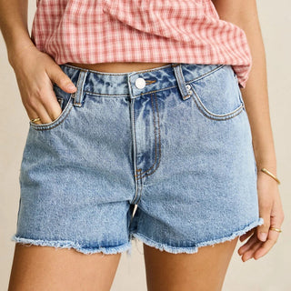 Rhythm Wanderer Denim Short in Blue, 100% cotton mid-rise relaxed boyfriend fit with frayed raw-edge hem, concealed front fly, back patch pockets, belt loops, and Rhythm logo clamp at waistband