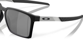 Oakley Exchange Sun Sunglasses in Satin Black with Prizm Black lenses, mixed material O Matter front with stainless steel temples and B1B grip textured Unobtainium earsocks, 11% light transmission grey base lens optimized for bright light, heritage-inspired design