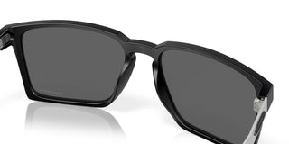 Oakley Exchange Sun Sunglasses in Satin Black with Prizm Black lenses, mixed material O Matter front with stainless steel temples and B1B grip textured Unobtainium earsocks, 11% light transmission grey base lens optimized for bright light, heritage-inspired design