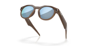 Oakley Meta HSTN smart glasses in Brown Smoke with Prizm Deep Water Polarized lenses, Meta AI, camera, and audio.