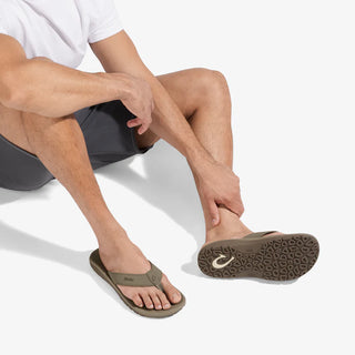 Person wearing brown sandals on a white background