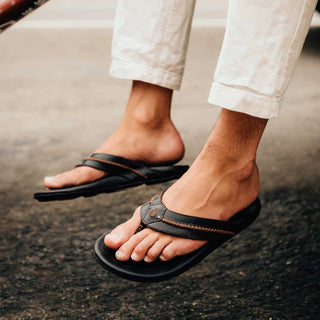 OluKai Mea Ola Leather Sandals in Dark Java/Dark Java — premium full-grain leather with canoe lash whipstitching, octopus laser-etched footbed, microfiber lining, and handsewn leather toe post