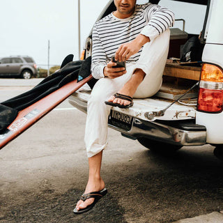 OluKai Mea Ola Leather Sandals in Dark Java/Dark Java — premium full-grain leather with canoe lash whipstitching, octopus laser-etched footbed, microfiber lining, and handsewn leather toe post