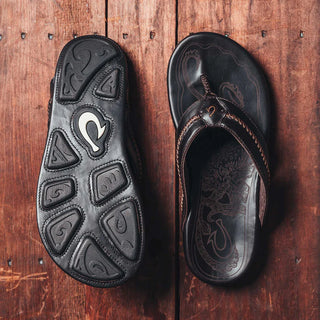 OluKai Mea Ola Leather Sandals in Dark Java/Dark Java — premium full-grain leather with canoe lash whipstitching, octopus laser-etched footbed, microfiber lining, and handsewn leather toe post