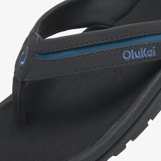 OluKai 'Ohana Pālua Men's Beach Sandals in Black/Slate Blue, synthetic split strap with jersey knit lining, signature 'Ohana compression-molded EVA footbed, and non-marking rubber coral-inspired lug outsole