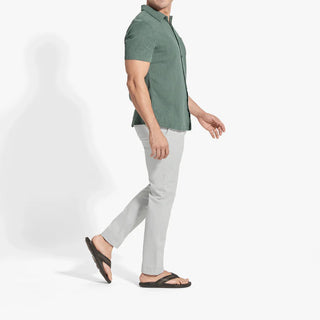 OluKai Mea Ola Mano leather sandals in Dark Java/Mustang with woven straps and shark-inspired etched detailing.