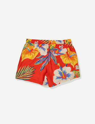 Model wearing Duvin Tropic Floral Swim Shorts in red with multicolored tropical flowers and leaves and a white drawstring