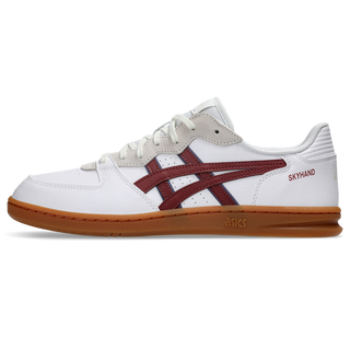 ASICS SKYHAND OG sneaker in white and brisket red with suede paneling, gum outsole, and retro handball-inspired design.