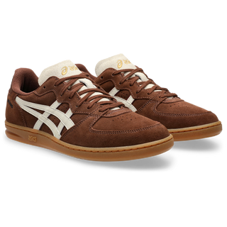 ASICS SKYHAND OG in reddish brown and oatmeal with suede panels, gum outsole, and retro handball-inspired silhouette.