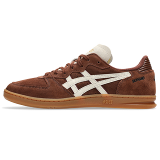 ASICS SKYHAND OG in reddish brown and oatmeal with suede panels, gum outsole, and retro handball-inspired silhouette.