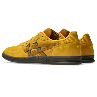 ASICS SKYHAND OG sneaker in hornet and spice curry with suede panels, gum outsole, and retro-inspired court silhouette.