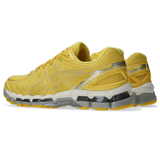 ASICS GEL‑KAYANO 20 in Banana Cream/Chrome Yellow with supportive FLUIDFIT™ cage and GEL® inserts.