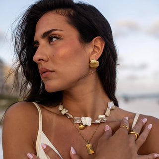 Gold earrings with minimalist sculptural design and smooth polished surface, secured with push back closure.