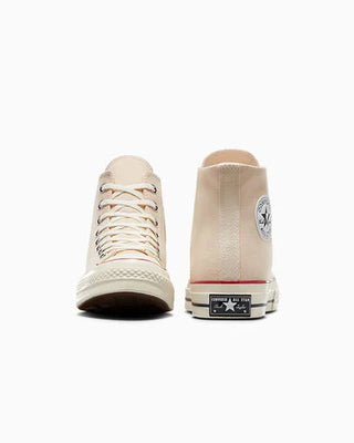 Beige high-top sneakers with a visible brand logo on a white background