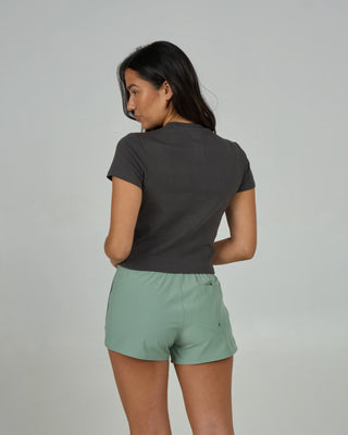 Charcoal women’s fitted baby tee with Salty Crew chest screen print, short sleeves, soft coastal knit.