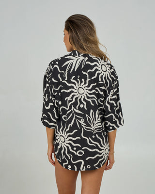 Black oversized tunic with kimono sleeves, scallop hem, side slits, relaxed beach vibe.