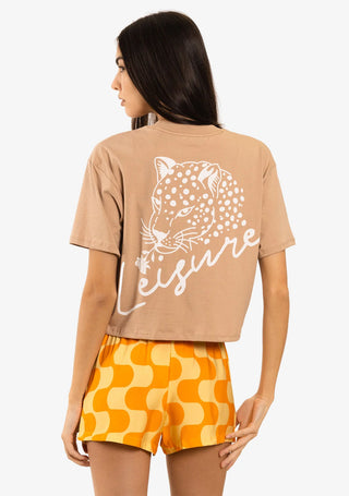 A casual yet chic woman modeling the Duvin Leisure Crop Tee in Tan, a high-quality Peruvian Pima cotton tee with a cropped boxy fit, custom dyed in a versatile Tan color, finished with a distinctive Duvin branded side seam label.