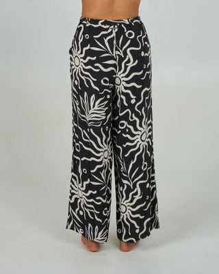 Black beach pant with elastic waist, rope drawcord, front trouser pockets, and metal Salty Crew back branding.