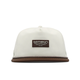 melin Coronado Brick Hydro Hat in Frosted Birch with an off-white crown, brown flat visor, rectangular melin patch, patterned rope trim, and perforated side panels.