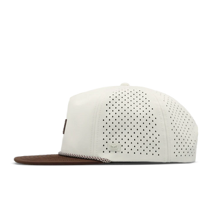 melin Coronado Brick Hydro Hat in Frosted Birch with an off-white crown, brown flat visor, rectangular melin patch, patterned rope trim, and perforated side panels.