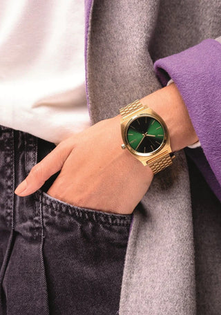 An image of the Nixon Time Teller Gold/Green Sunray watch, showcasing its sleek gold design and stainless steel bracelet.