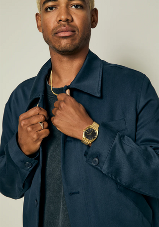 Nixon Time Teller All Gold/Black Sunray analog watch with gold stainless steel bracelet and black sunray dial.