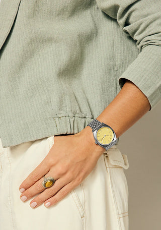 Nixon Time Teller Silver/Butter analog watch with stainless steel bracelet and soft butter-yellow dial.