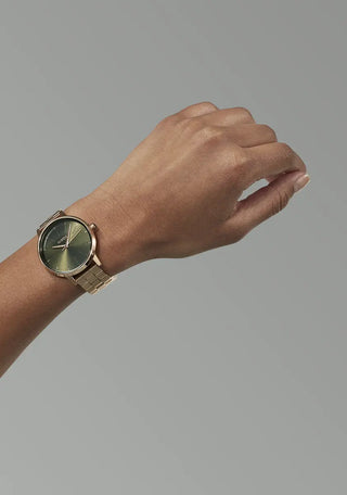 Nixon Kensington Watch in Rose Gold with Olive Sunray dial, engraved indices, and stainless steel bracelet.