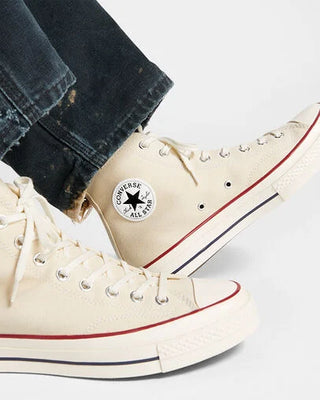 Beige Converse high-top sneakers with a black star logo on a white background