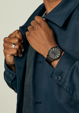 Nixon Sentry Leather Matte Black/Gold watch with black leather strap and gold-accented analog dial.
