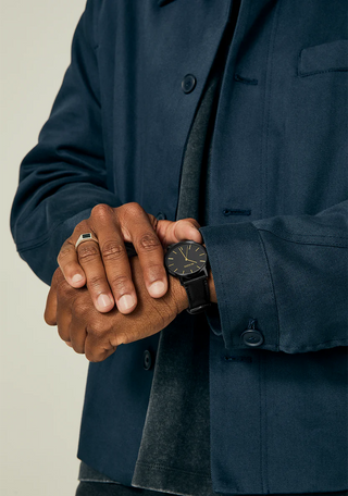 Nixon Porter Leather All Black/Gold analog watch with black leather strap and gold-accented black dial.