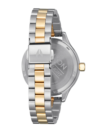 Image of the Nixon Optimist Silver and Gold Watch, a fashionable and sustainable wristwatch with a distinctive solar panel and polished design.