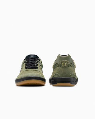 Pair of green sneakers with black soles on a white background