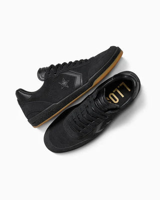 Black sneakers with gold accents on a white background