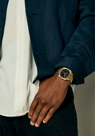 Nixon Fremont 40 Gold/Black analog watch with gold stainless steel bracelet and black dial.