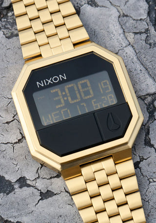 Nixon Re-Run All Gold digital watch with gold stainless steel bracelet and retro LCD display.