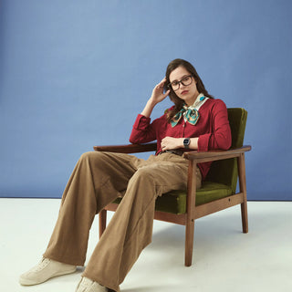 Woman sitting in a chair against a blue background