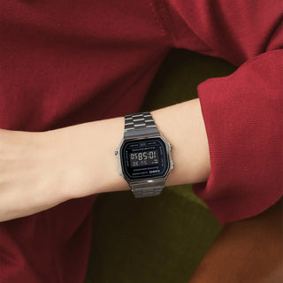 Digital watch on a wrist with a red sleeve
