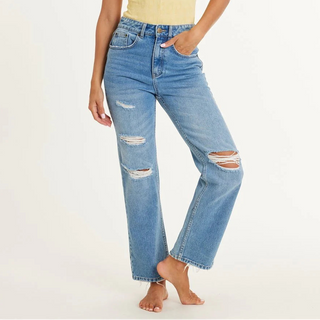 Person wearing distressed blue jeans on a white background