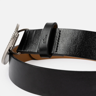 Dime Skull Leather Belt in Black with an oval silver-tone buckle featuring skull motifs and a large cursive D, a black keeper, and tan interior