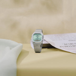 Casio Vintage AQ240E-2A watch with silver bracelet, light blue sunray dial, and analog-digital display.