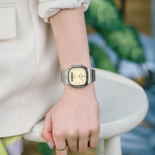 Casio Vintage AQ240E-7A2 watch with silver bracelet, white matte dial, and analog-digital display.