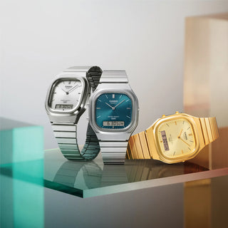 Three Casio watches in silver, blue, and gold on a reflective surface with a light gray background.