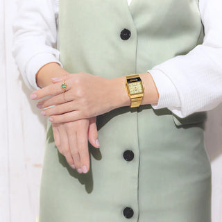 Person wearing a gold watch on a light green jacket with a white shirt.