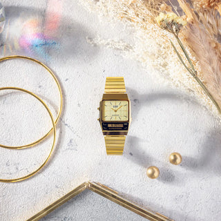 Gold watch with matching jewelry on a textured surface