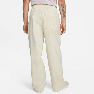 Image of the Nike SB x Doyenne Skate Pants in white, featuring tapered legs, adjustable waistband, and zippered pockets.