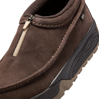 Nike ACG Izy in Baroque Brown/Sanddrift Velvet with moccasin-inspired styling, contrast stitching, zipper closure, and a rugged rubber outsole.